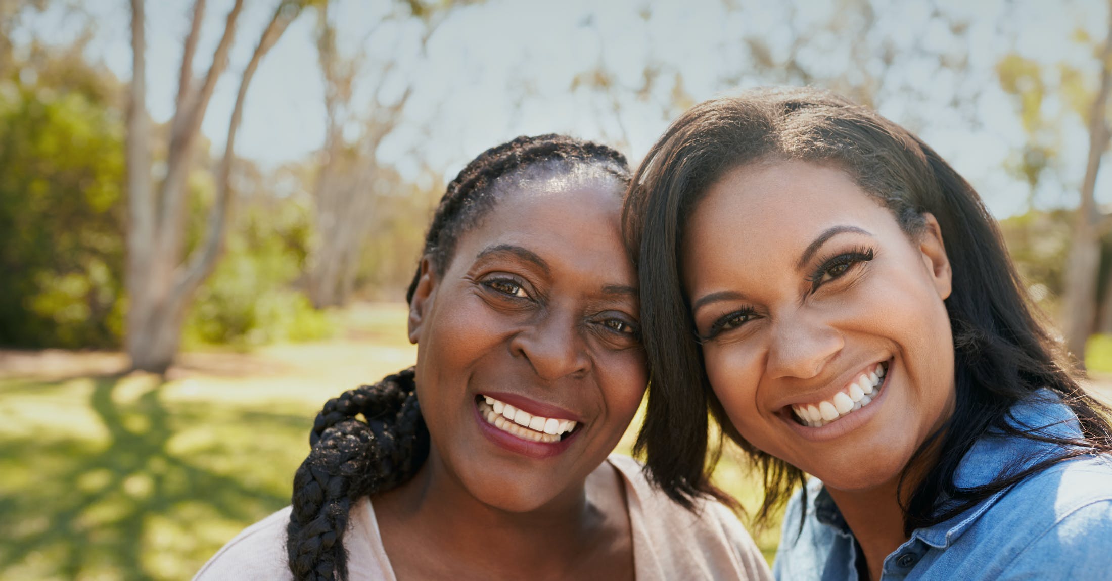 Mother and daughter smiling outdoors
