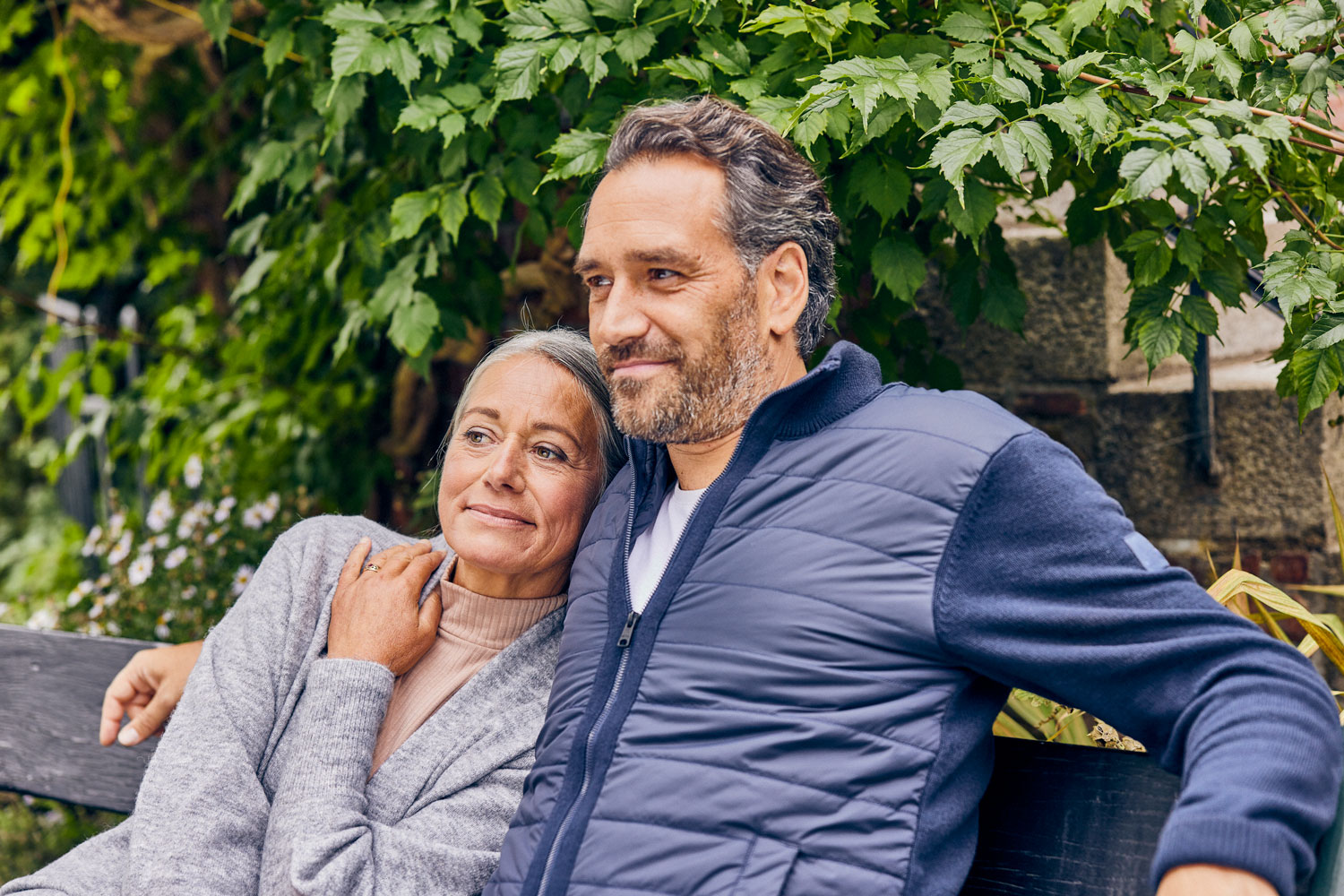 A couple smiles sitting in a park