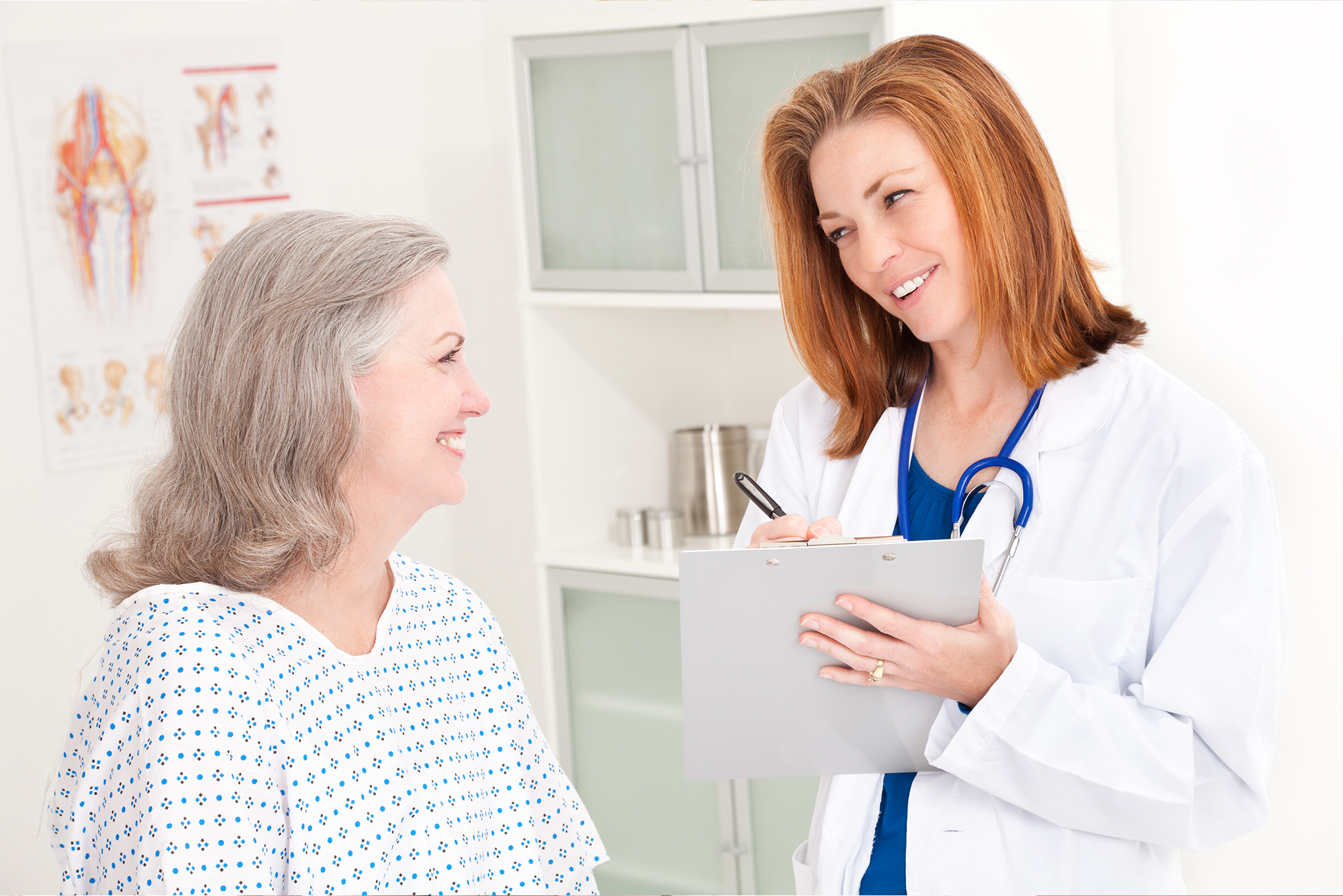 Physician taking notes while talking to a patient