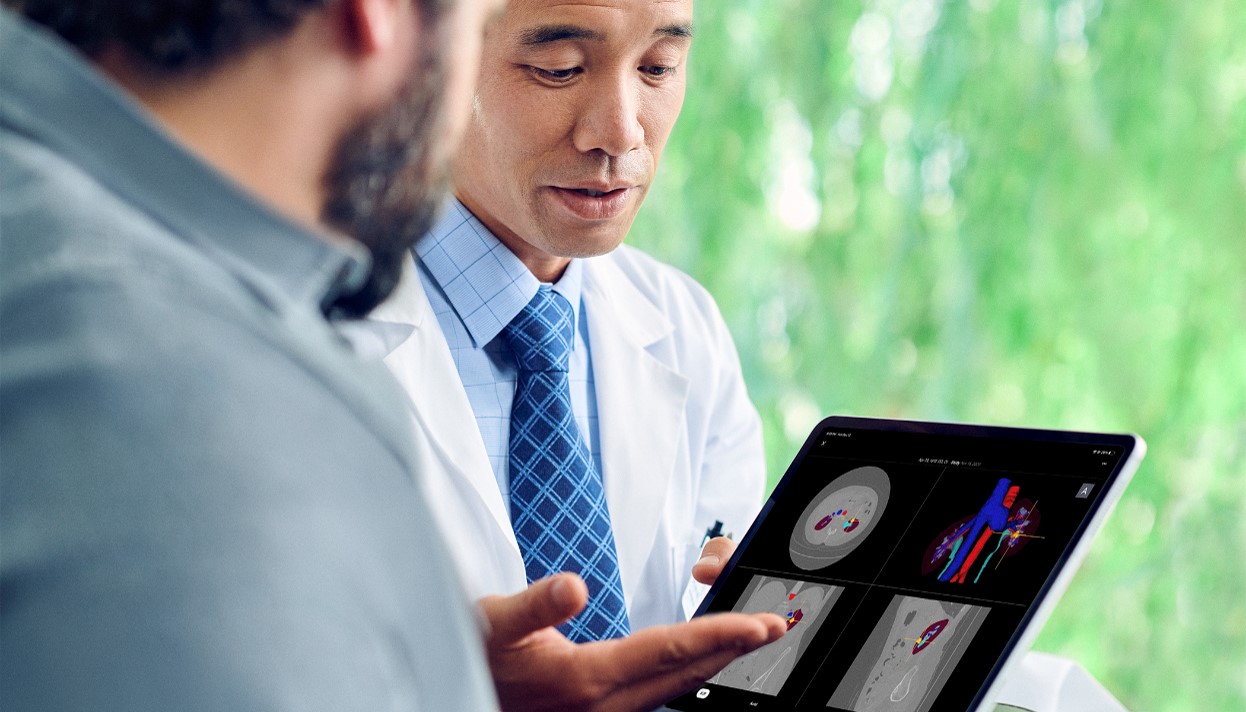 Patient and physician reviewing a digital 3D model and scans on a tablet