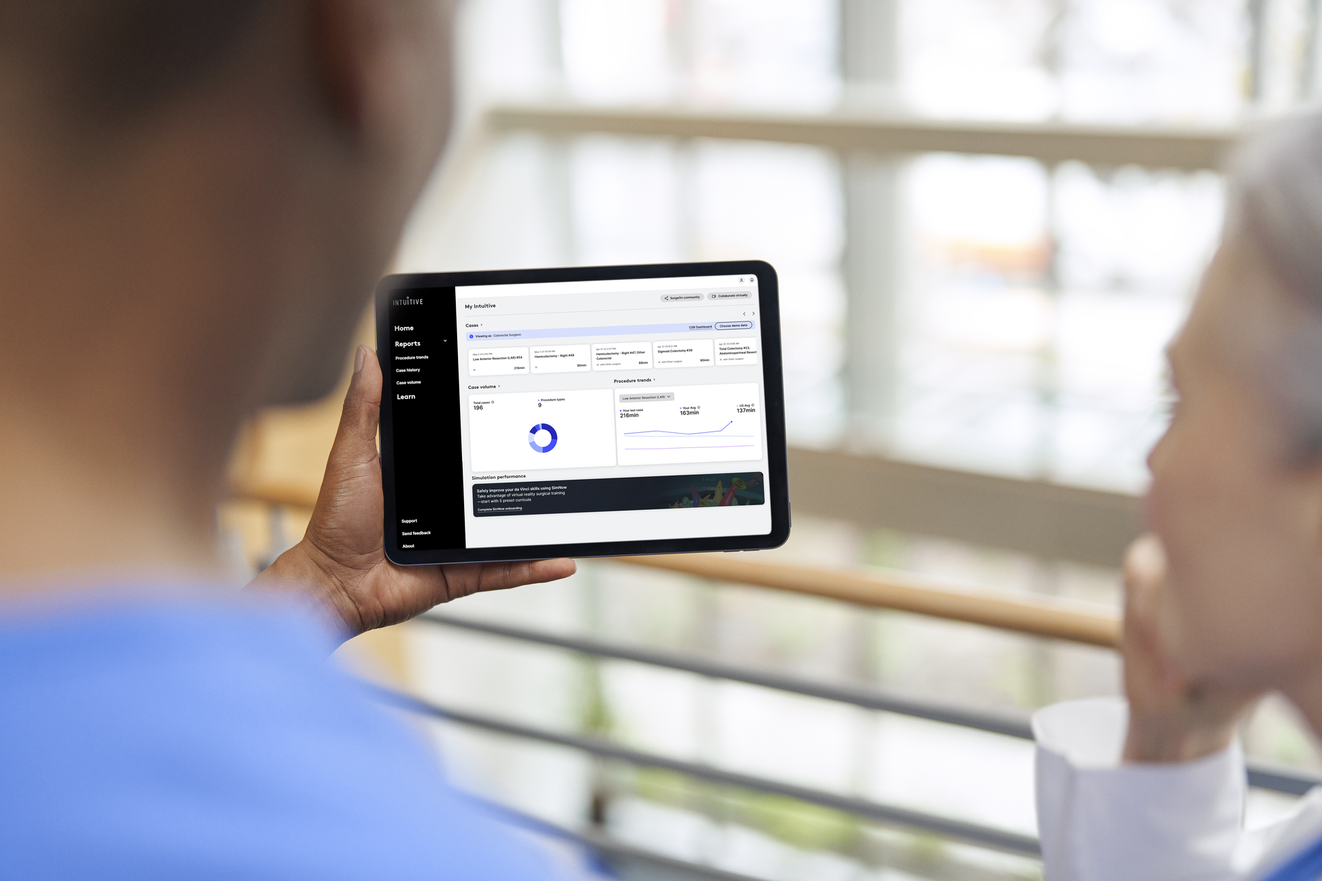 Two surgeons viewing My Intuitive data on a tablet