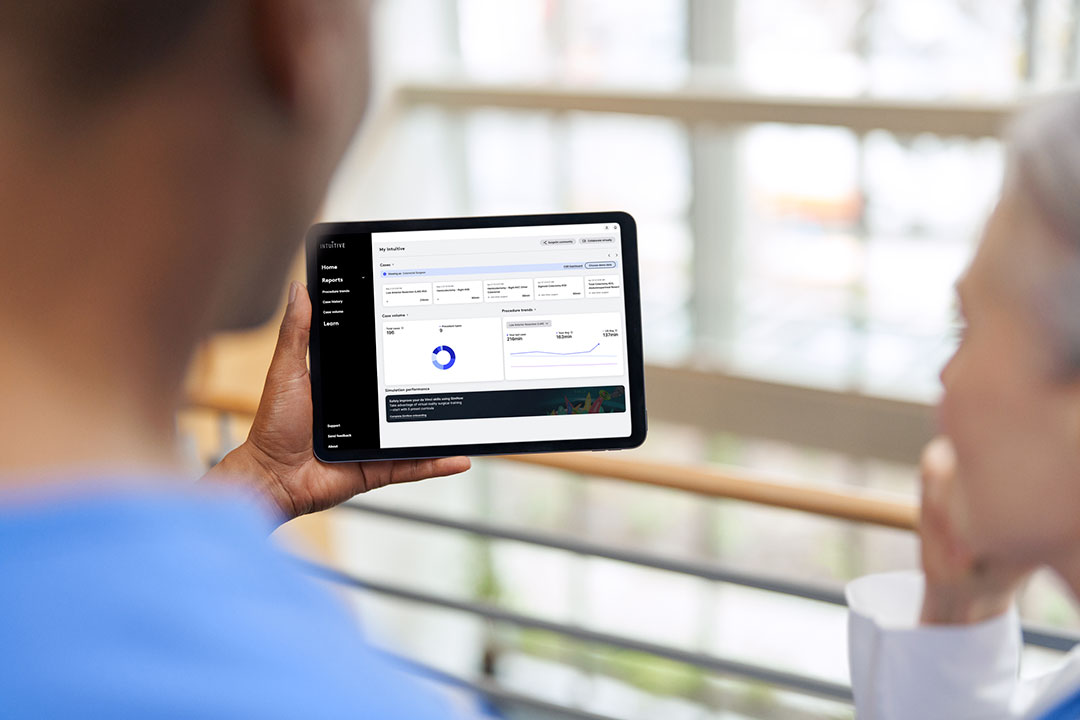 Two surgeons viewing My Intuitive data on a tablet