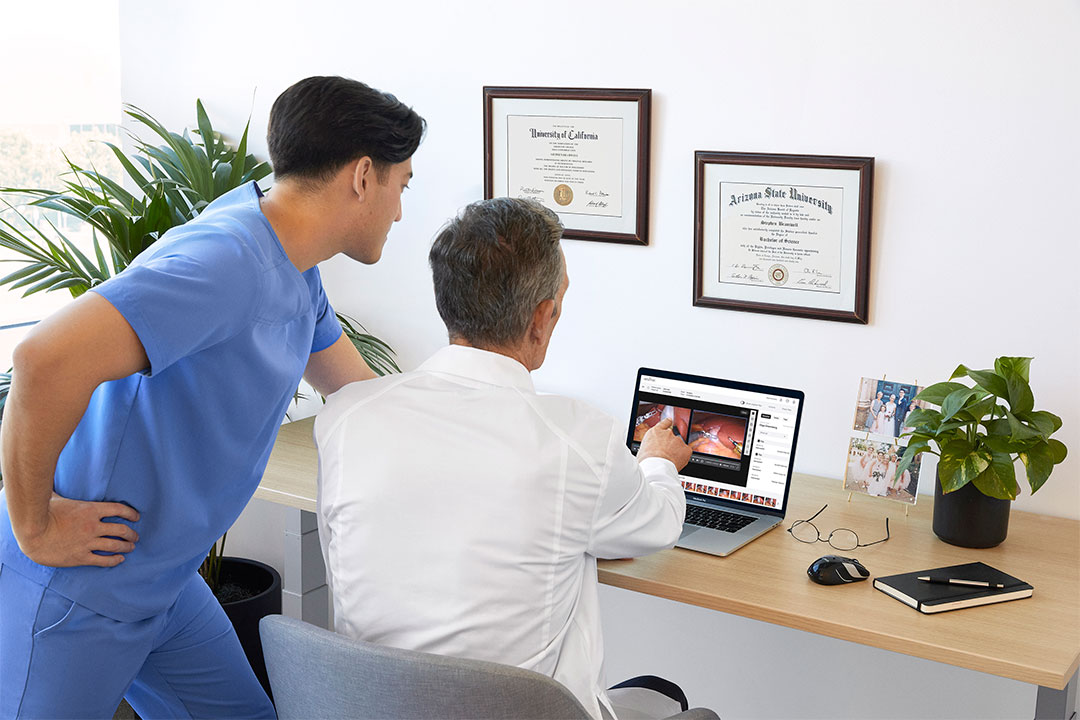 Surgeon and team member discuss case video in office