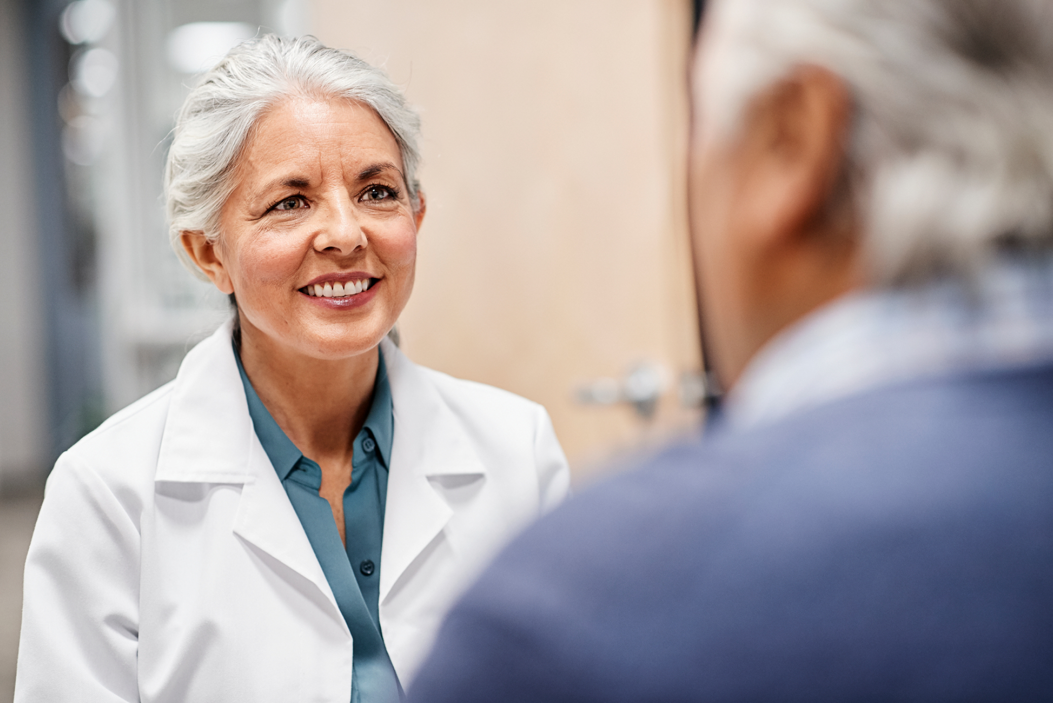 Doctor smiling consulting older patient