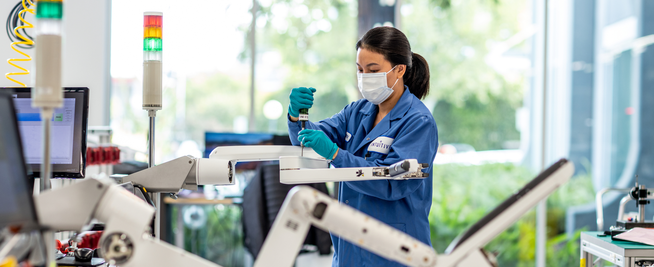 A technician assembles an arm of a da Vinci Xi system.