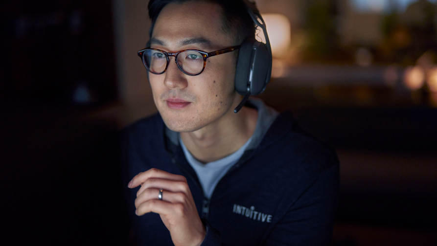 Photo of OnSite service engineer wearing a headset and working at his computer late at night.