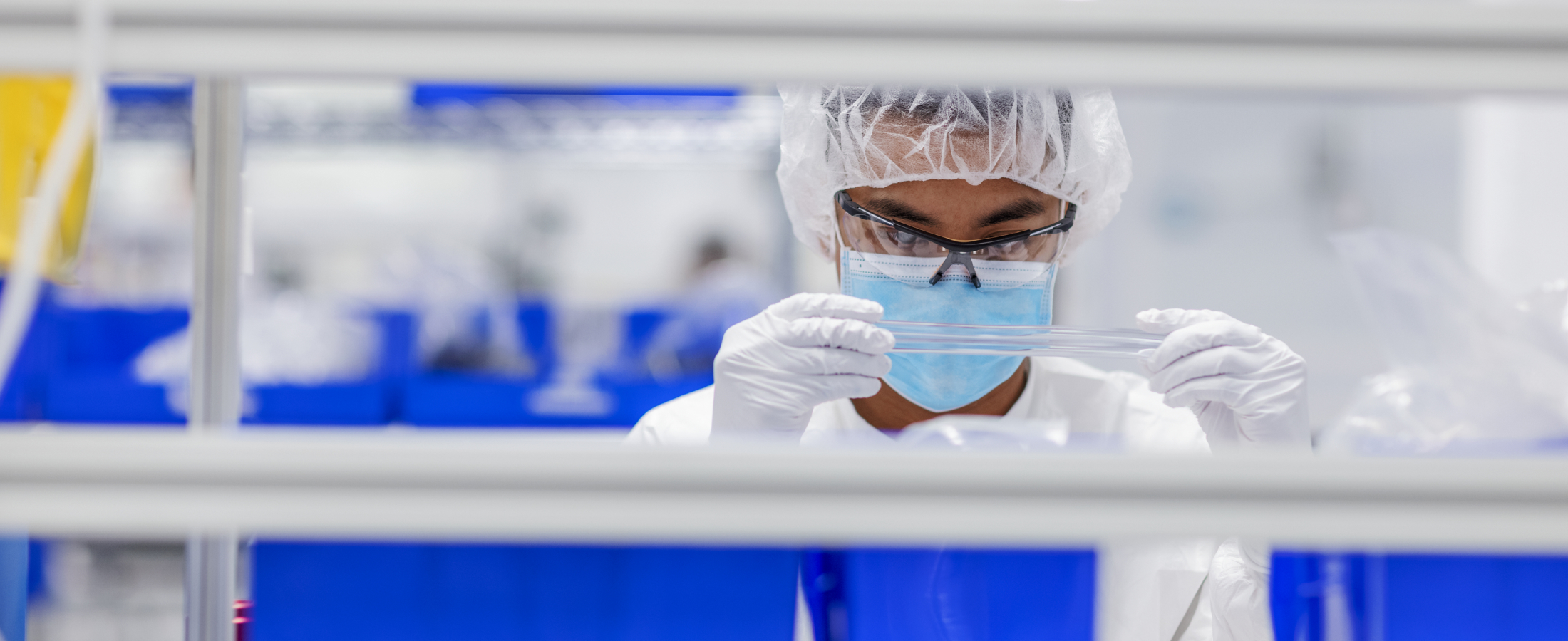 Lab researcher in a mask studying a sample